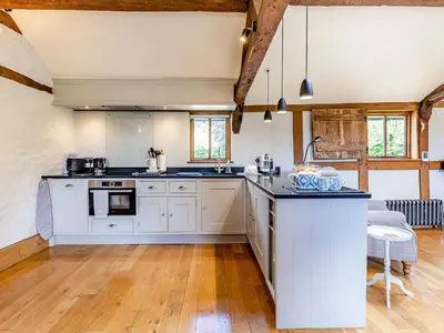 a kitchen with white cabinets and a kitchen island at The Cider Mill in Kings Pyon