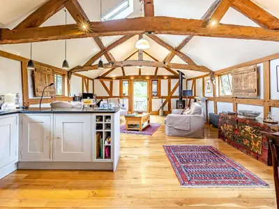 a kitchen and living room with wooden ceilings and wooden floors at The Cider Mill in Kings Pyon