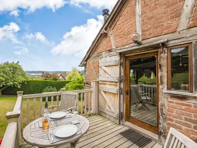 a wooden deck with a table and chairs on a building at The Cider Mill in Kings Pyon