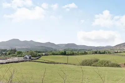 a green field with mountains in the background at 2 Bryn Tirion in Tanygrisiau