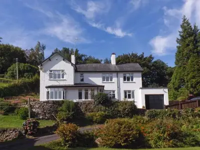 a white house with a fence in front of it at Llechwedd in Dolgellau
