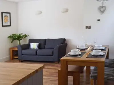 a living room with a blue couch and a table at Llechwedd in Dolgellau