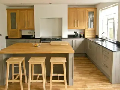 a kitchen with a large wooden island with bar stools at Llechwedd in Dolgellau