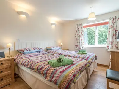 two beds in a bedroom with green towels on them at The Schoolhouse Bakehouse in Bishops Castle