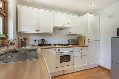 a kitchen with white cabinets and a sink at Gorwel in Blaenau-Ffestiniog
