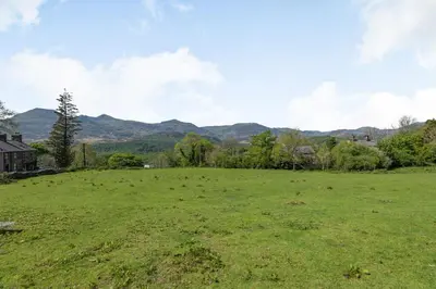 a field of grass with mountains in the background at Gorwel in Blaenau-Ffestiniog