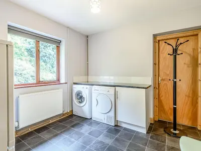 a laundry room with a washer and dryer at Llety Nest in Llanfachreth
