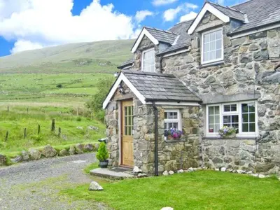 a stone house in the middle of a field at Stabal Cottage in Cross Foxes