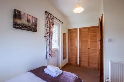 a bedroom with a bed with towels on it at Stabal Cottage in Cross Foxes
