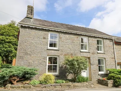 an old stone house with white windows at Derwen Villa in Mydroilin