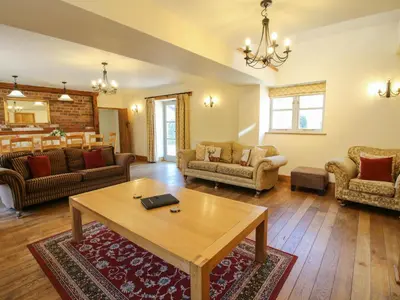 a living room with a table and a couch at Trooper's Barn in Acton Scott
