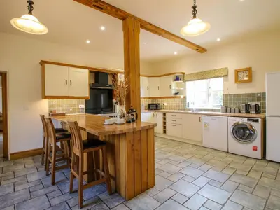a kitchen with a large wooden island in a kitchen at Trooper's Barn in Acton Scott