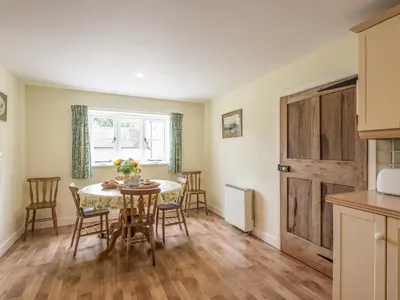 a kitchen and dining room with a table and chairs at Hope Hall Barn in Bromlow