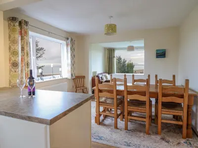 a kitchen and dining room with a table and chairs at The Villa in Harlech