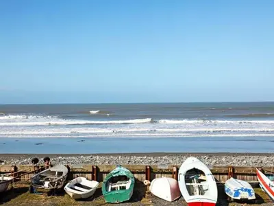 a group of boats are lined up on the beach at Trysor Y Mor in Borth