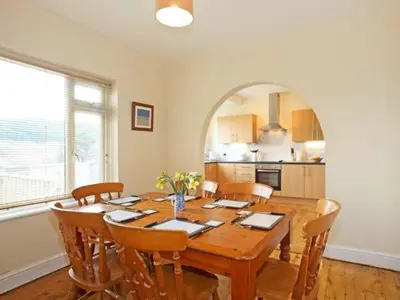 a dining room with a wooden table and chairs at Trysor Y Mor in Borth
