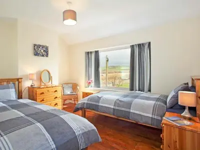 a bedroom with two beds and a window at Trysor Y Mor in Borth