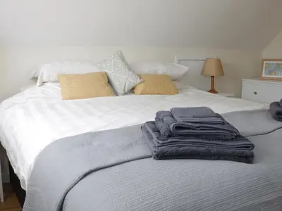 a white bed with towels on top of it at Bicton Lodge in Clun