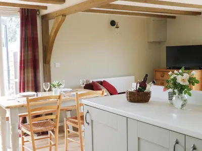 a kitchen and dining room with a table and chairs at Bicton Lodge in Clun