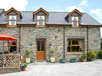 a stone house with a brown door and windows at Tangaer Cottage in Cellan