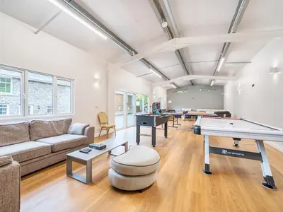 a living room with a couch and a ping pong table at Old Rectory Cottages in Aberhafesp