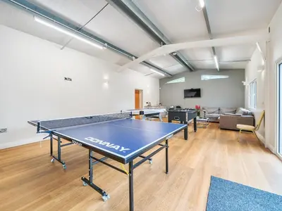 a ping pong table in a room with a couch at Old Rectory Cottages in Aberhafesp