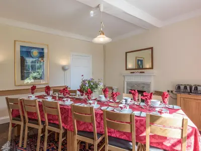 a dining room with a table with red napkins at The Old Schoolhouse and Cottage in Bishops Castle