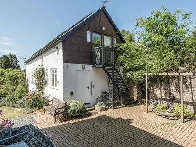 a house with a staircase leading up to the front of it at The Old Schoolhouse and Cottage in Bishops Castle
