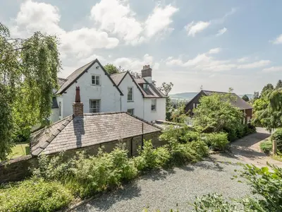 an external view of the house with its garden at The Old Schoolhouse and Cottage in Bishops Castle