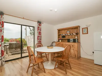 a kitchen and dining room with a table and chairs at Wheelbarrow Cottage in Stoke Prior
