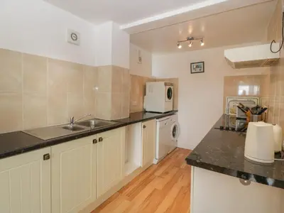 a kitchen with a sink and a microwave at Wheelbarrow Cottage in Stoke Prior
