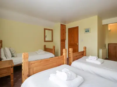 a room with three beds with white towels on them at Wheelbarrow Cottage in Stoke Prior