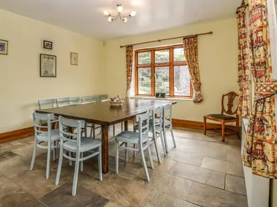 a dining room with a wooden table and chairs at Wheelbarrow Castle in Stoke Prior