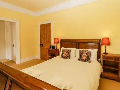 a bedroom with a bed with two night stands and two lamps at Wheelbarrow Castle in Stoke Prior