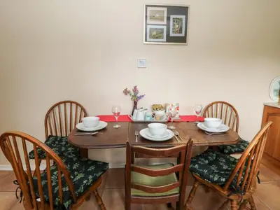 a dining room table with four chairs and a table and chairsktop at Bryn yr Haf in Llanfair Clydogau