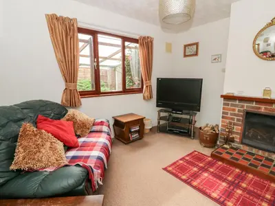 a living room with a couch and a television at Bryn yr Haf in Llanfair Clydogau
