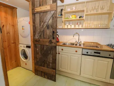 a kitchen with a sliding barn door in a kitchen at Beudy Dolpebyll in Llangadfan