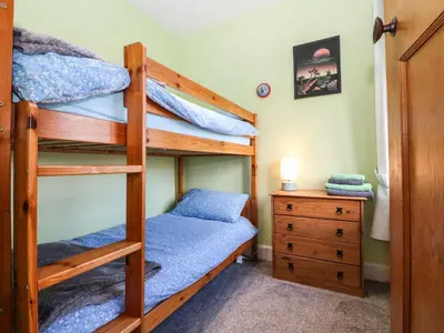 a bedroom with two bunk beds and a dresser at Bron Aber in Arthog