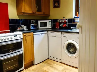 a kitchen with a washing machine and a washer at The Wilderness in Bromlow