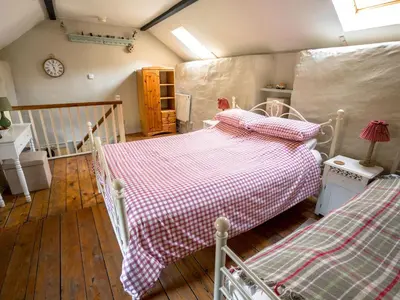 a bedroom with two beds and a clock on the wall at The Wilderness in Bromlow