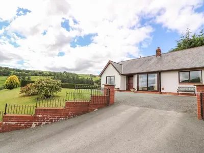 a house with a brick fence and a driveway at Drainbyrion Farm House in Van
