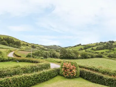 a garden with hedges and a winding road at Drainbyrion Farm House in Van