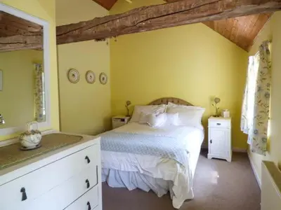 a bedroom with a white bed and yellow walls at Crud-y-Barcud in Pumpsaint