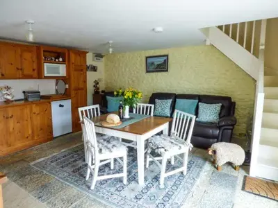 a living room with a table and chairs and a couch at Crud-y-Barcud in Pumpsaint