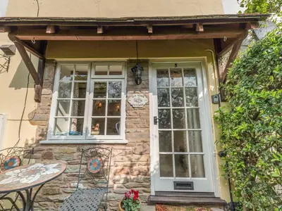 a stone house with a white door and windows at Old Town Cottage in Ludlow