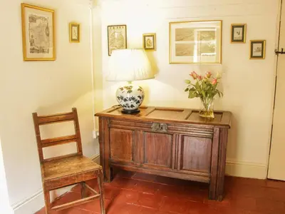 a table with a lamp and a chair in a room at Penymaes in Chirk
