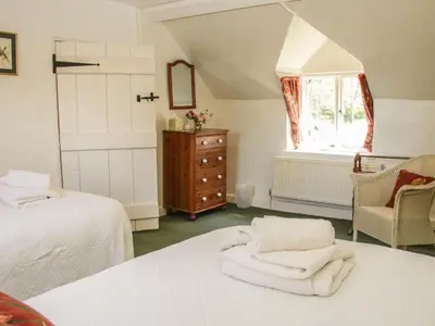 a bedroom with two beds and a dresser and a window at Penymaes in Chirk
