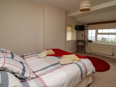 a bedroom with two beds with towels on them at Aberdauddwr in Llanwnen