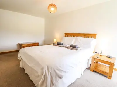 a bedroom with a white bed with two towels on it at Ysgubor Las in Dolgellau