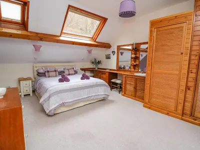 a bedroom with a bed and a sink and a mirror at Tanyrallt Farm in Beulah